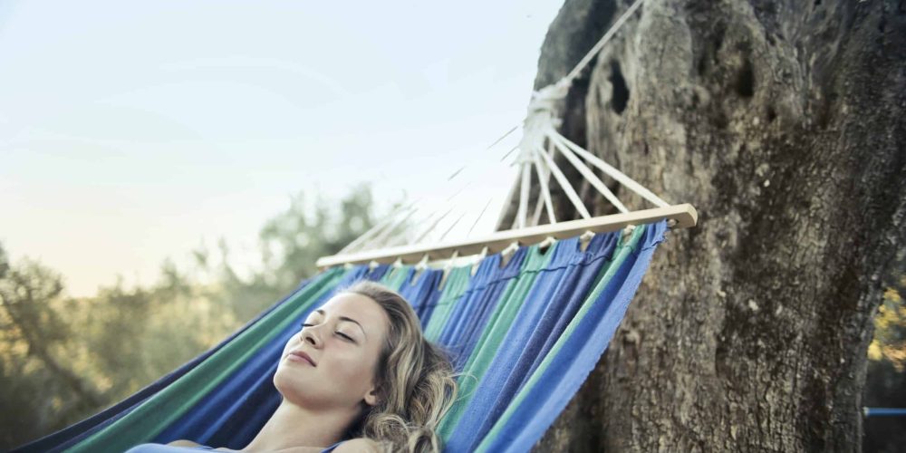 Vrouw doet middagdutje in hangmat
